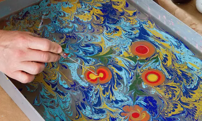 Image of a person marbled ink for paper design