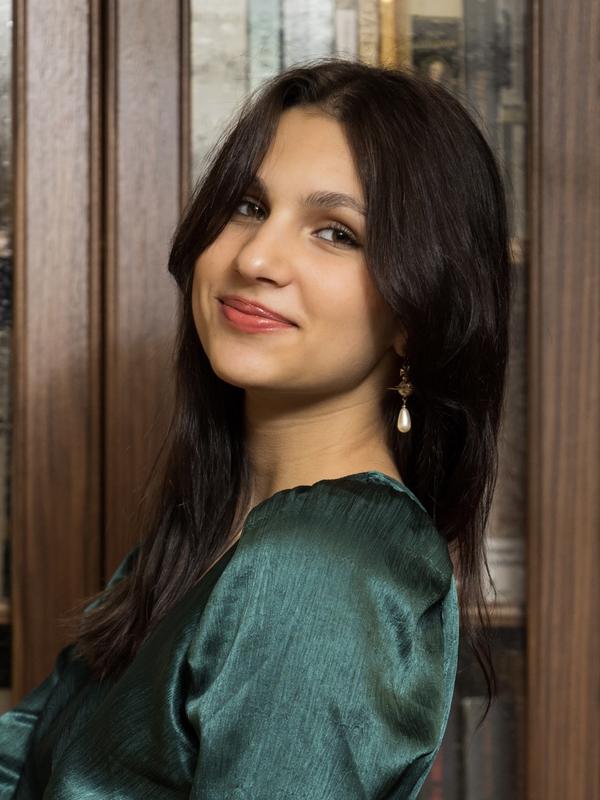 Headshot of Andrea Rachita standing in front of a bookcase.
